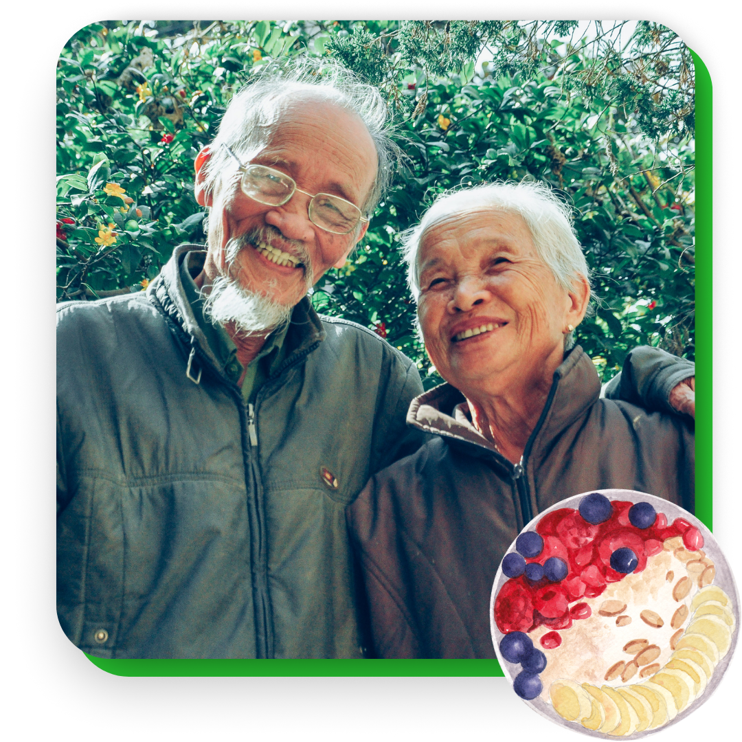 older couple smiling in front of shrubbery